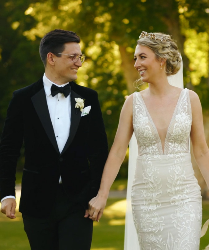 Wedding couple walking hand in hand through forest